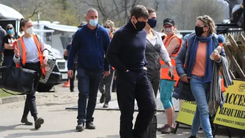 Actor Tom Cruise (centre) walking flanked by film crew