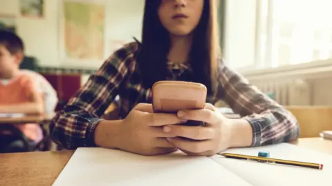 Getty Images Schoolgirl using mobile phone, file pic