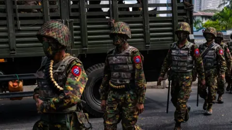 Getty Images Myanmar military soldiers stand guard after arriving overnight with armoured vehicles on February 15, 2021 near the Central Bank in Yangon, Myanmar.