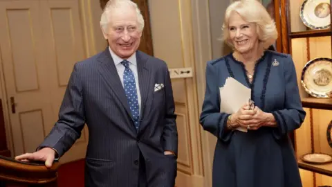 PA Media King Charles III smiling alongside Camilla, the Queen Consort