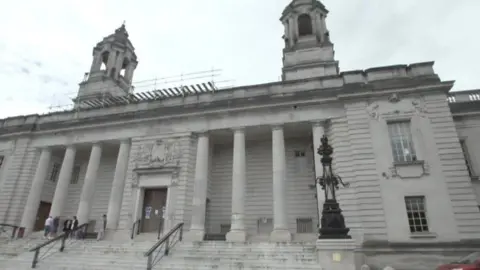 Cardiff Crown Court. There are steps leading up to the doors which have four pillars on either side