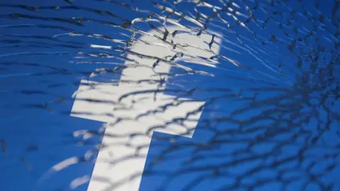 Reuters Facebook logo behind shattered glass