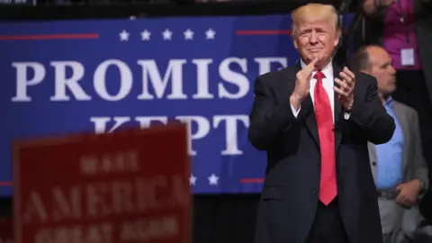 Getty Images Donald Trump claps at a rally in Iowa.