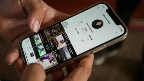 Getty Images A phone with TikTok held in someone's hand