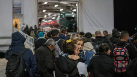 Reuters A large crowd of people enter a ferry