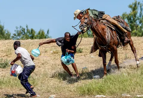 PAUL RATJE / AFP A US Border Patrol agent on horseback tries to stop a Haitian migrant from entering an encampment.