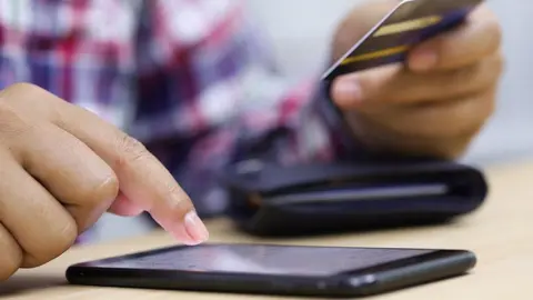 Getty Images Someone entering card details into a phone