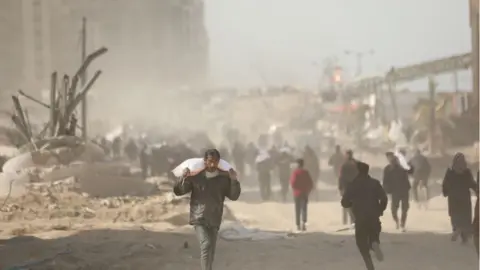 Getty Images man carries flour from truck west of Gaza city on 6 March