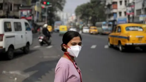 EPA A beneficiary medical staff crosses the road after receiving a COVID-19 vaccine shot, manufactured by Serum Institute of India, at the vaccination centre at Amri Hospital in Kolkata, India, 03 February 2021.