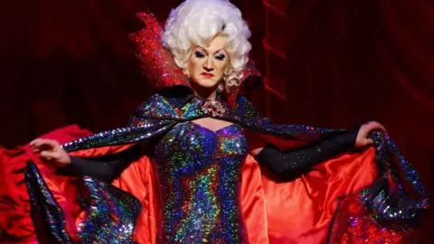 PA Media Paul O'Grady as Lily Savage performs as the Wicked Queen in Snow White & The Seven Dwarfs at the Victoria Palace Theatre, London in 2004