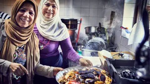 Reuters Intlak Al Saiegh and Ahlam Saeid cooking at the Hubb Community Kitchen