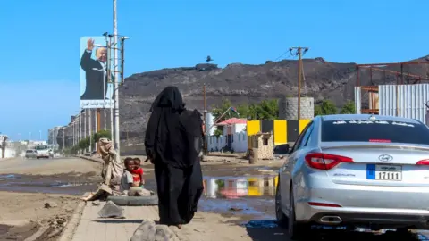 AFP A woman and her children beg for money in Aden, Yemen (27 April 2020)