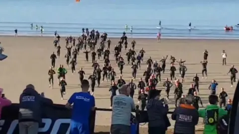 @_BARRY ISLAND_/ Twitter Triathlon runners on beach