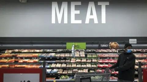 Getty Images Shopper in the meat section of a supermarket in Washington, DC