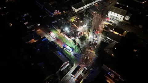 Skytech Aerial Solutions Ltd An aerial view of the house fire in Grand Drive with fire engines in the street and smoke coming from the burnt out house