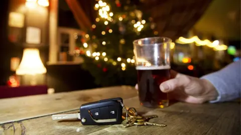 PA A man drinks a pint of beer while his car keys sit on a bar top