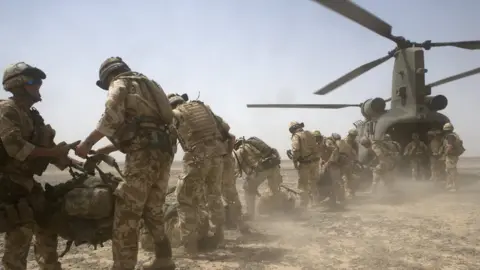 Getty Images British soldiers in Afghanistan by a helicopter