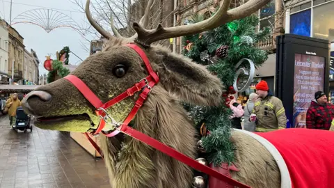 BBC Rudolph in Leicester city centre. It is covered in tinsel and has horns and reins around his face.