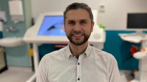 Katharine Da Costa/BBC Krzysztof Slosarczyk , smiling in a white shirt