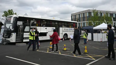 Getty Images People queue for a vaccination at a bus in Bolton