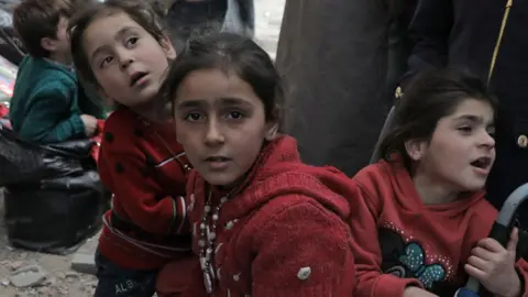 AFP Children wait to be evacuated from the town of Douma, in the rebel-held Eastern Ghouta region (22 March 2018)