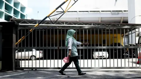 Getty Images A woman walks past the forensics wing of the Hospital Kuala Lumpur in the Malaysian capital