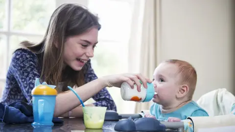 Getty Images Girl feeding a baby