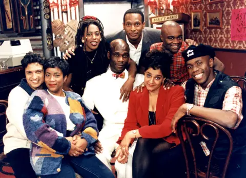 BBC Kulwinder Ghir, Llewella Gideon, Judith Jacob, Leo Chester, Felix Dexter, Ishmael Thomas, Meera Syal and Robbie Gee seen in a promotional photo of series five of The Real McCoy