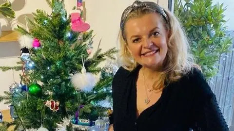 Tracy Ralph in front of a christmas tree