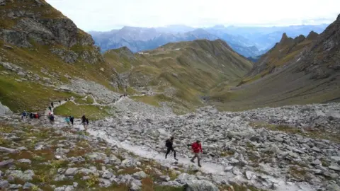 Getty Images People hike the Swiss Alps to pay their respects to a dead glacier