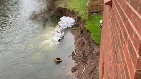 Leigh Adams river water against house