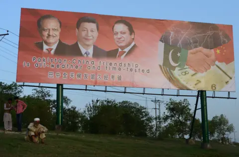 FAROOQ NAEEM/GETTY A Pakistani man sits under a welcoming billboard ahead of a visit by Chinese President Xi Jinping in Islamabad on April 17, 2015.