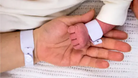 Getty Images Hand of newborn in mother's hand