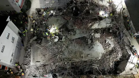 Reuters Aerial view of the collapsed building and rescue teams on site in George, South Africa. Photo: 6 May 2024