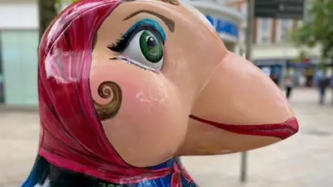 Puffins Galore A puffin sculpture with a headscarf painted on