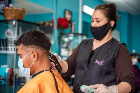 Getty Images Hair salon, wearing masks