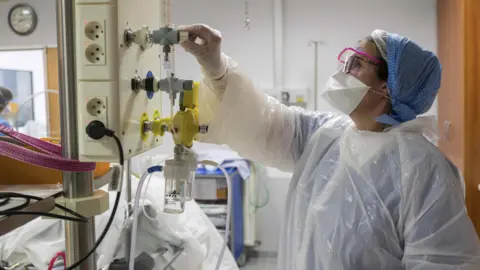 Getty Images Member of medical staff adjusts oxygen supply in French hospital