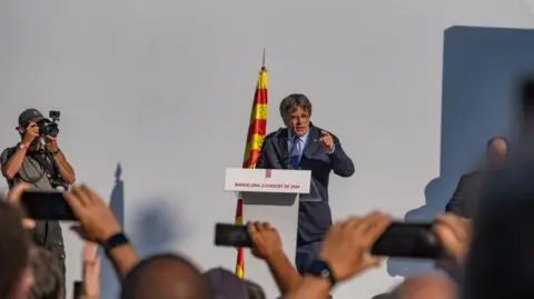 Former President of the Generalitat of Catalonia Carles Puigdemont seen on stage defying the arrest warrant issued by the Spanish justice system