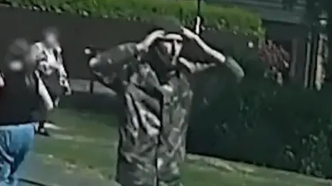 Northumbria Police Still from dashcam showing Billy Stokoe at the scene of the crash. His face is exposed in the middle of a balaclava and he has his hands up to his head in apparent shock.