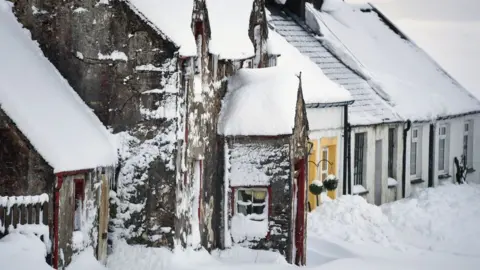 Getty Images row of cottages under snow