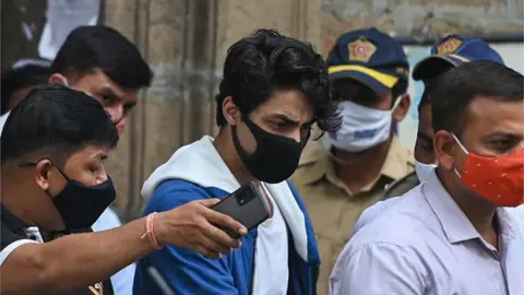 Getty Images Aryan Khan escorted to court by Narcotics Control Bureau (NCB) officials for a bail plea hearing in Mumbai on October 8, 2021