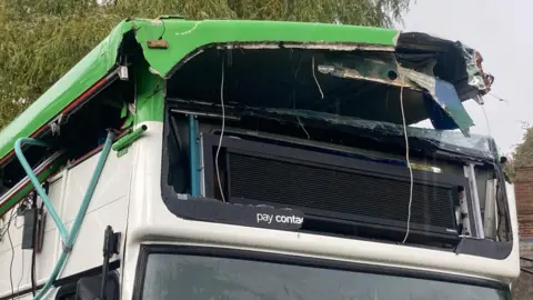 Mousumi Bakshi/BBC A bus with its roof placed back on