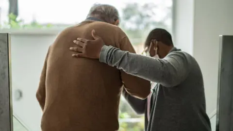 Getty Images Man being helped