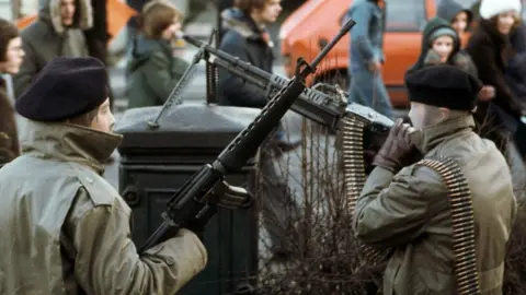 Getty Images Armed IRA members at a demonstration in Derry in 1978