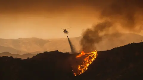 AFP A firefighting helicopter drops water at the Sand Fire on July 23 2016 near Santa Clarita, California