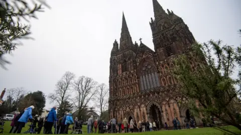 PA Media Members of the public queue outside Lichfield Cathedral