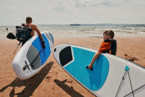 David Hares  Simon and his son head out to sea on their paddleboards