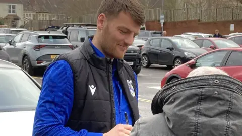 Keith Brookman Bristol Rovers striker Chris Martin signs and autograph for a fan outside the Memorial Stadium