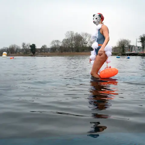 Teri Pengilley An image of a woman walking into a lake whilst wearing a bathing suit and a mask