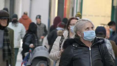 BBC Woman wearing mask on Strand Street